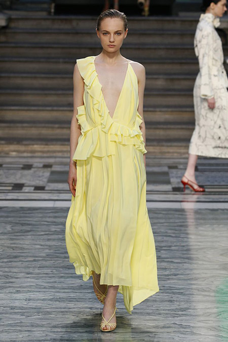 Desfile Victoria Beckham na LFW Primavera / Verão 20, modelo veste vestido midi com babados amarelo pastel.