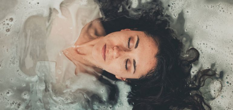 Aplicativos para cuidar da saúde mental: imagem de mulher deitada em banheira com água, vista de cima
