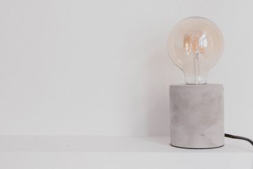 Lâmpada em luminária de concreto, desligada, faz pensar em como economizar na conta de luz