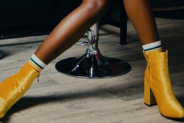 perna de uma mulher negra usando bota amarela