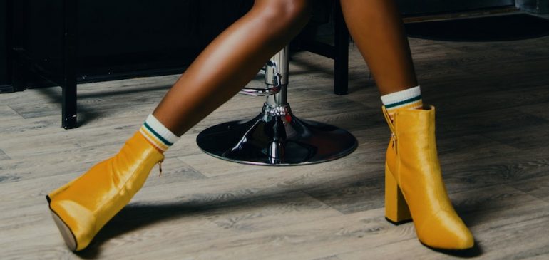 perna de uma mulher negra usando bota amarela